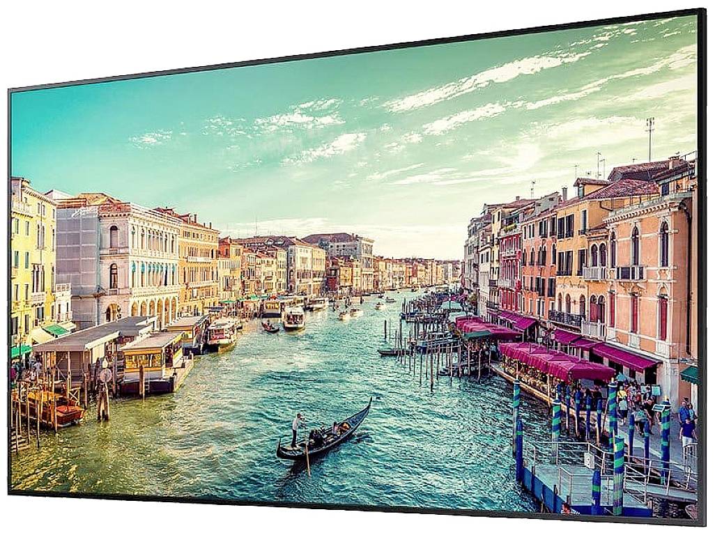 Ein Kanal in Venedig, umgeben von historischen Gebäuden. Eine Gondel fährt auf dem Wasser, Touristen flanieren am Ufer entlang.