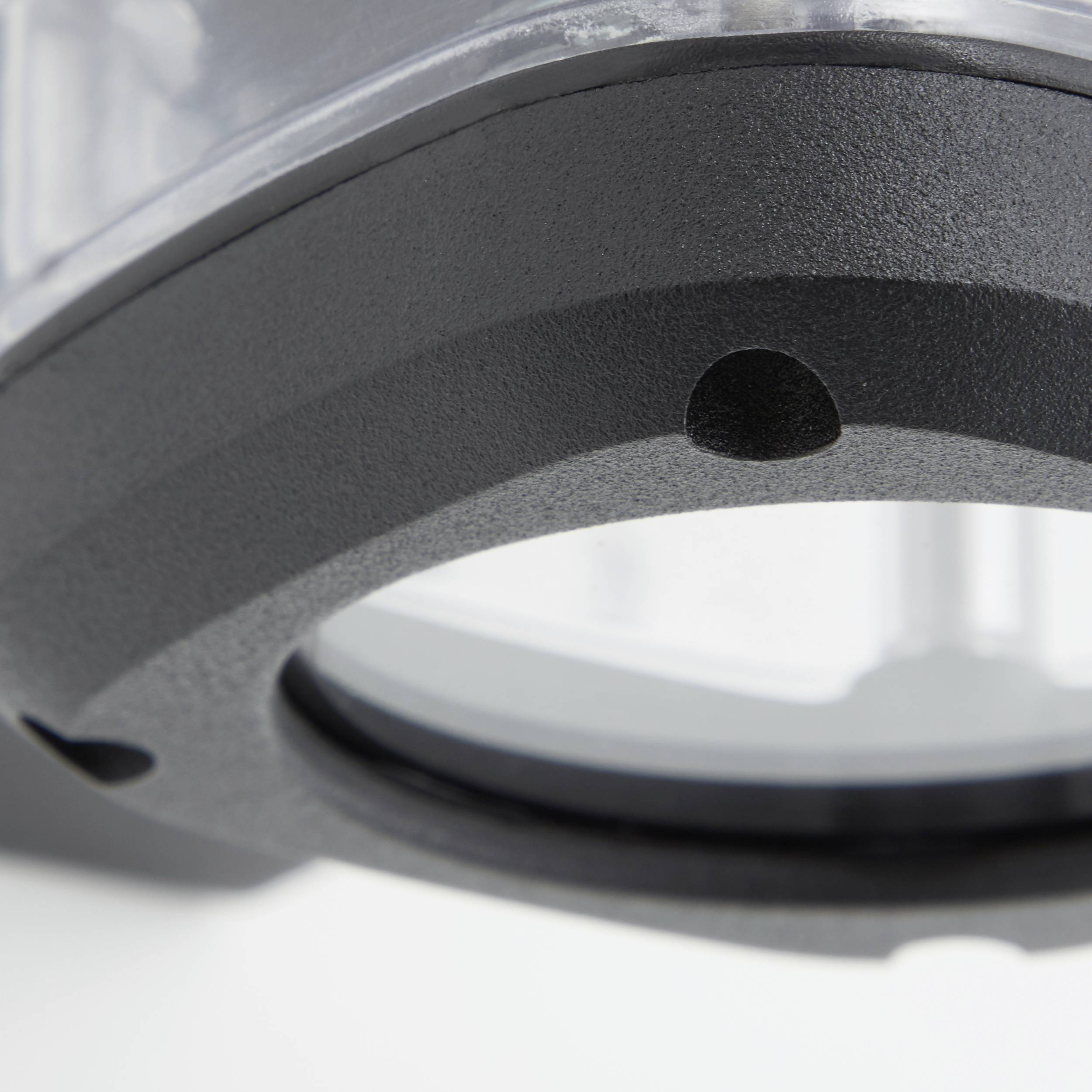 Ein schwarzes, rundes Objekt mit einem Loch in der Mitte. Der Hintergrund ist unscharf, das Licht kommt von oben.