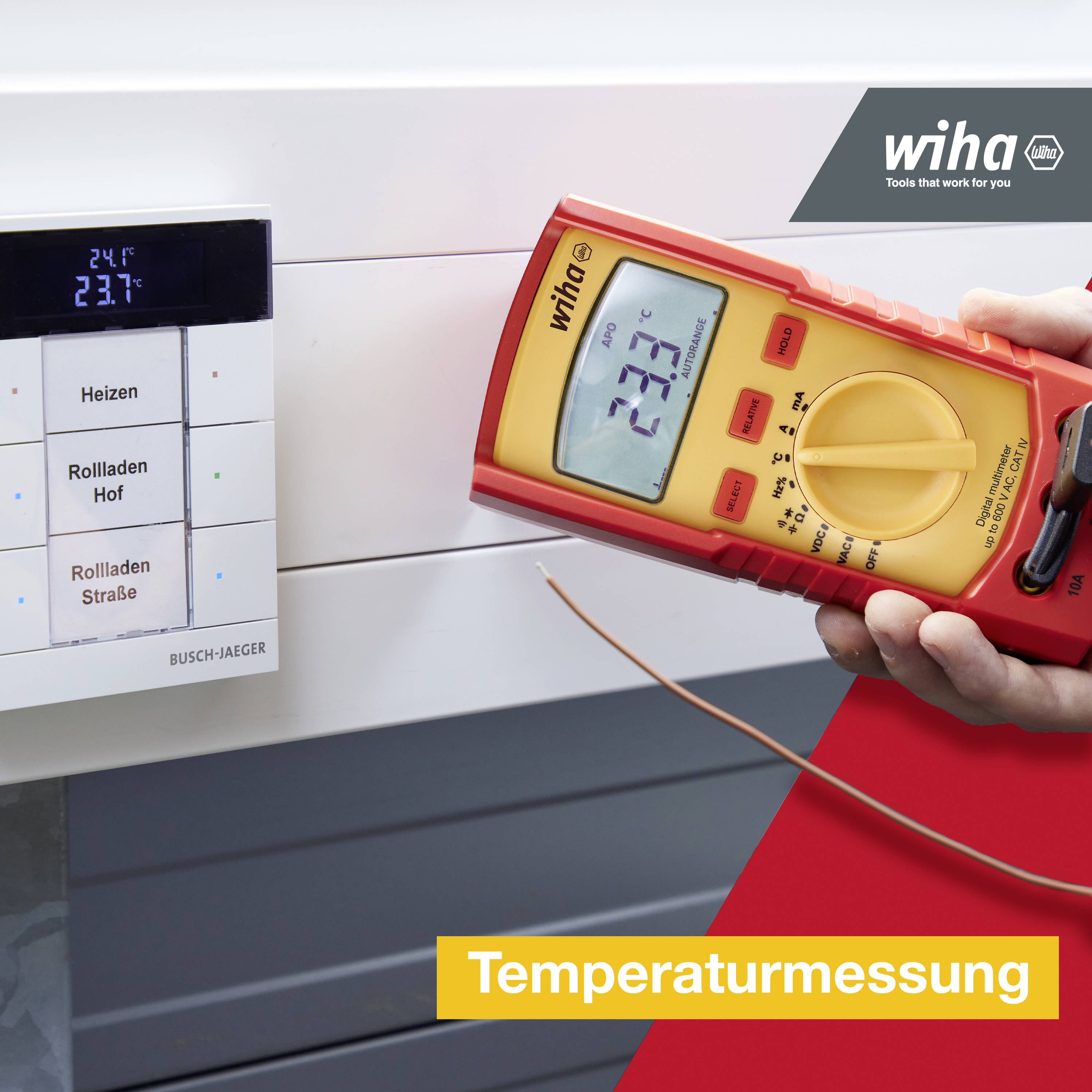 Eine Person misst die Temperatur mit einem Multimeter neben einem digitalen Wandthermostat; Aufschrift: 'Temperaturmessung'.