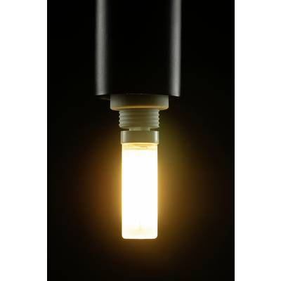 Eine glühende Glühbirne leuchtet warm in einem dunklen Raum und strahlt sanftes Licht aus.