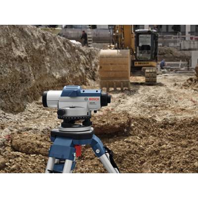 'Bauarbeiten einer Baustelle mit einem Bosch-Nivelliergerät im Vordergrund und einem Bagger im Hintergrund.'
