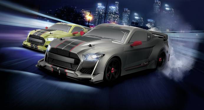 Das Bild zeigt zwei REELY Onroad-Modellautos mit Beleuchtung. Die qualmenden Räder zeigen, dass die Fahrzeuge an einem Driftrennen teilnehmen. Im Hintergrund sieht man die Lichter einer Großstadt.
