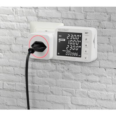 Ein Energiemessgerät ist in eine Steckdose eingesteckt. Es zeigt Messwerte wie 230,0 V Spannung und 10,00 A Stromstärke auf einem Display an.
