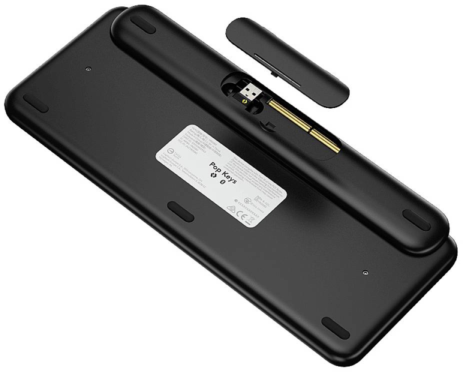 Eine schwarze Tastatur von hinten mit einem offenen Fach, das den USB-Dongle, Batterien und ein Etikett zeigt.