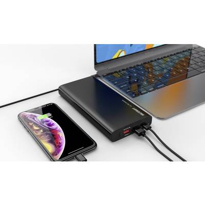 Ein Laptop und ein Smartphone werden gleichzeitig von einer Powerbank aufgeladen. Der Ladezustand des Smartphones wird angezeigt.