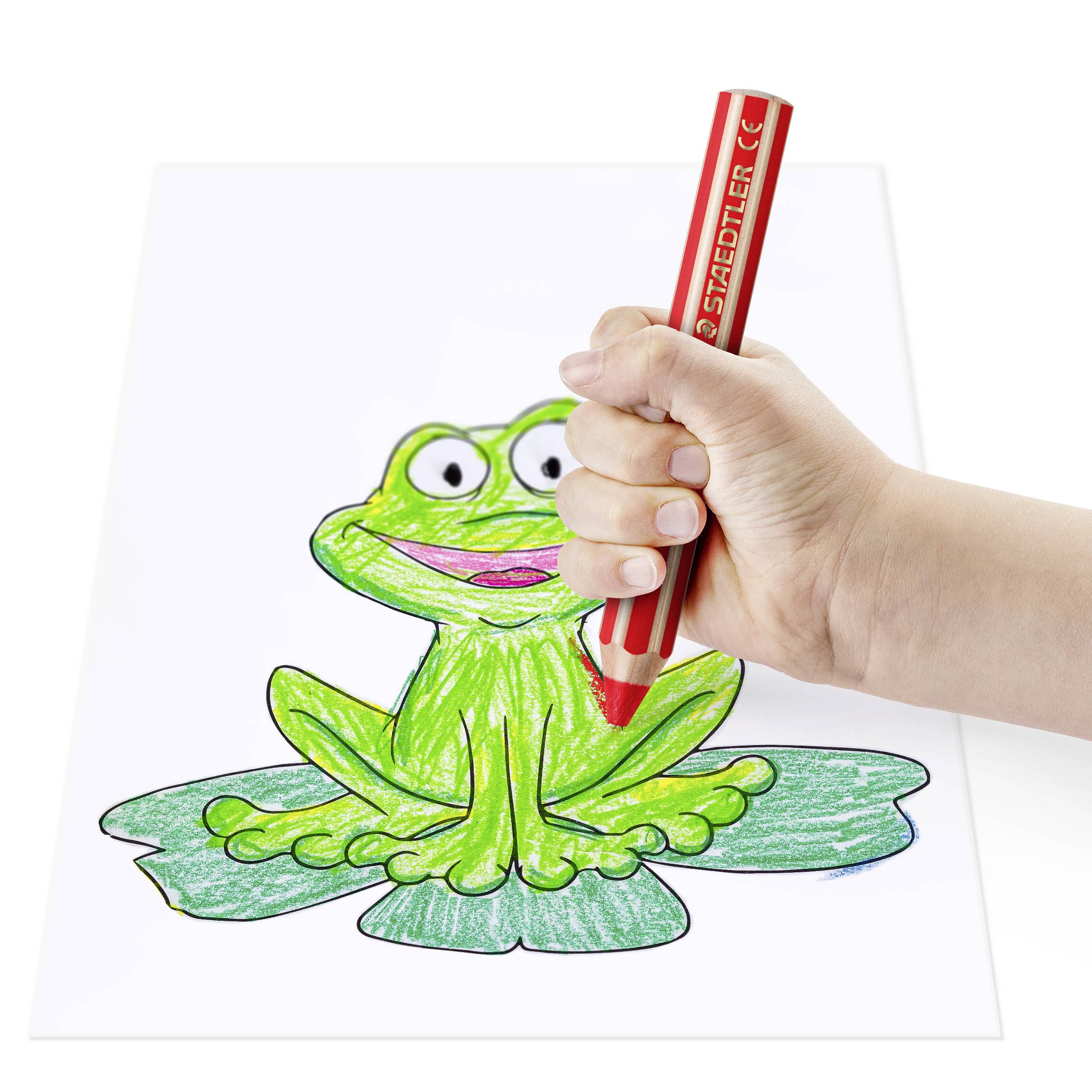 Eine Hand hält einen roten Stift und malt ein grünes Bild eines lächelnden Frosches auf einem Blatt Papier aus.