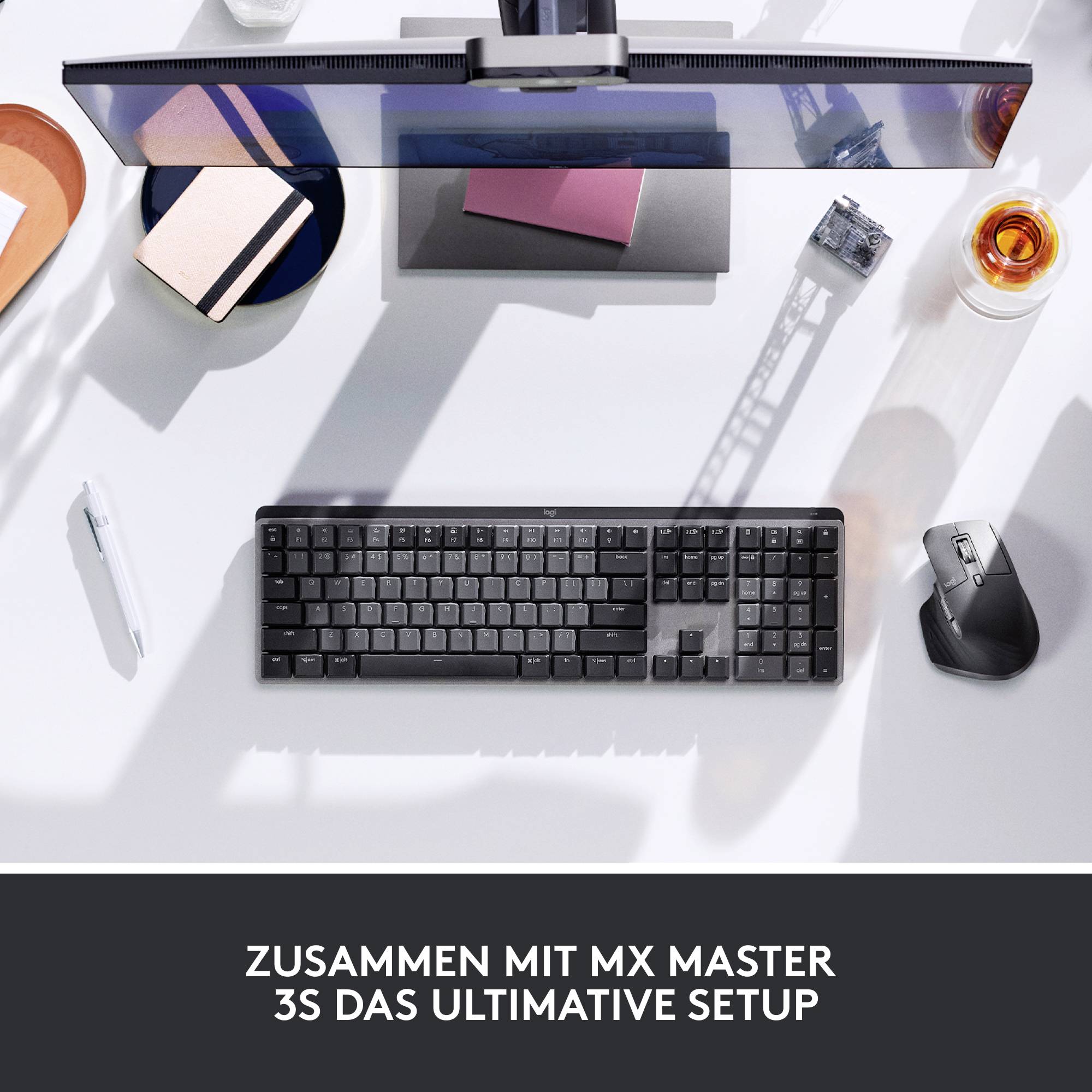 Eine stilvolle Büroumgebung von oben: Tastatur, Maus, Stift und Getränk auf einem Tisch. Text: 'Zusammen mit MX Master 3S das ultimative Setup'.