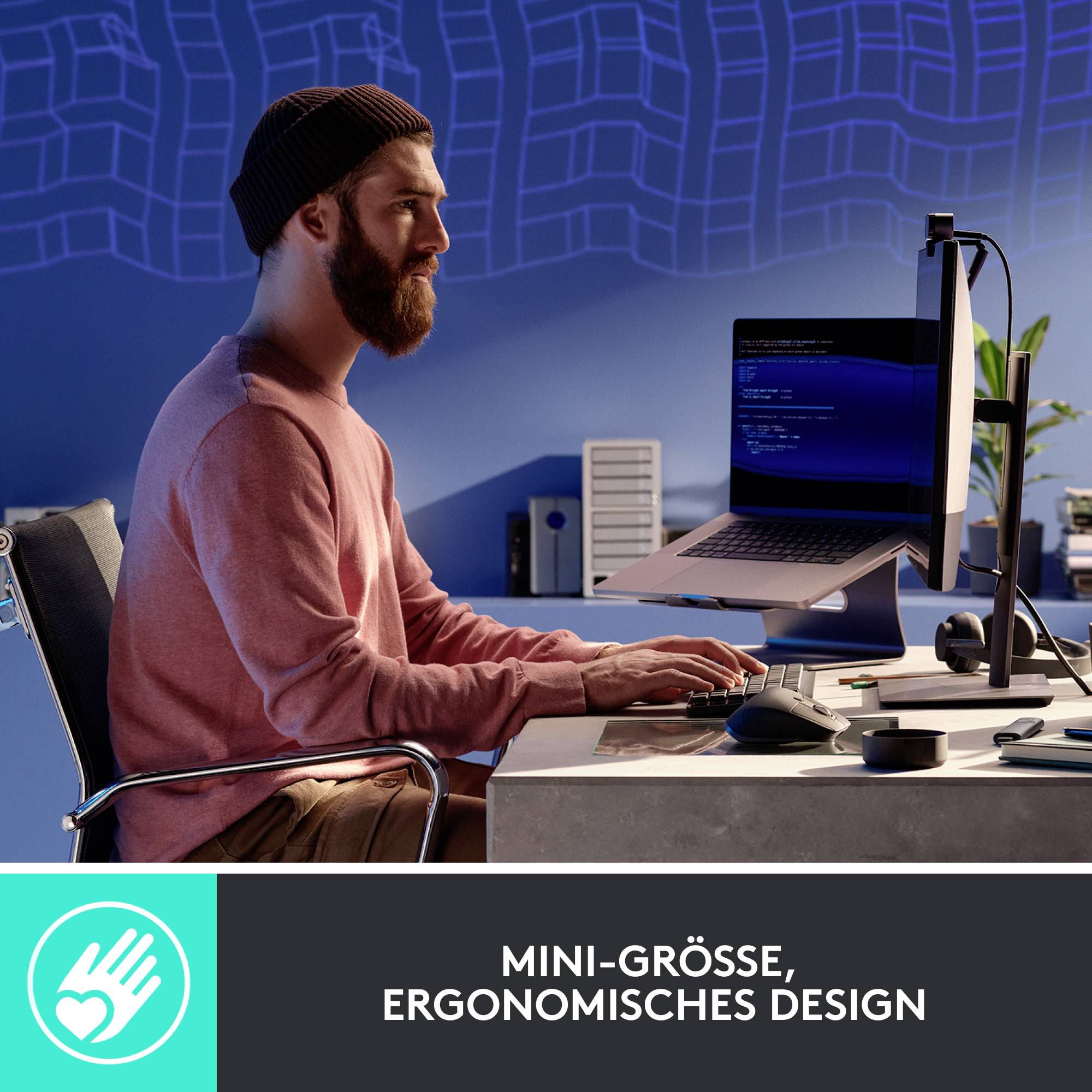Ein Mann sitzt an einem Schreibtisch mit einem ergonomischen Design. Vor ihm steht ein Computerbildschirm. Büroatmosphäre.