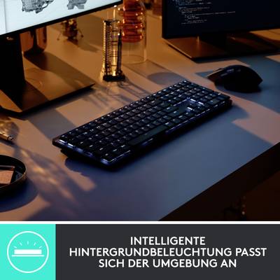 Ein Computerarbeitsplatz bei Nacht mit leuchtender Tastatur. Unten ist ein Textfeld mit der Aufschrift: 'Intelligente Hintergrundbeleuchtung passt sich der Umgebung an'.