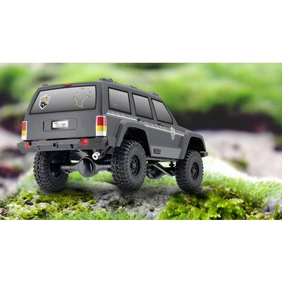 Ein graues SUV-Modellauto steht auf einer mit Moos bedeckten Oberfläche. Das Fahrzeug hat große Reifen und Aufkleber an den Seiten.