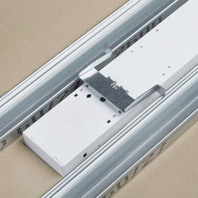 Ein weißer Kabelkanal aus Metall in einer Decke montiert, mit zwei parallel verlaufenden Schienen, auf beigem Hintergrund.