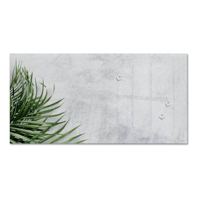 Erholsames Motiv mit grünen Palmenblättern vor einem schlichten, grauen Hintergrund. Minimalistische und beruhigende Szenerie.