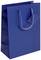 Blaue Geschenktüte mit tragfähigem Henkel und kleinem Etikett, bereit zum Verpacken von Geschenken.