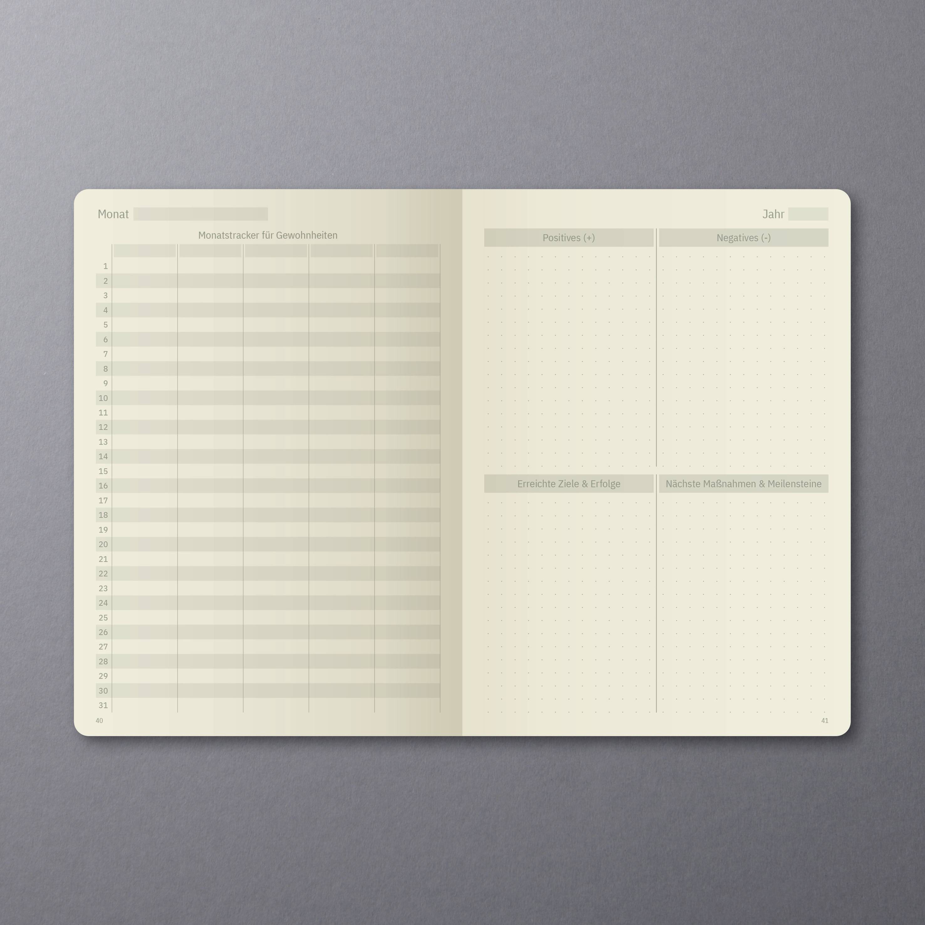 Ein aufgeschlagenes Notizbuch auf grauem Hintergrund mit einem Kalender für einen Monat, Platz für Gewohnheiten und Notizen.