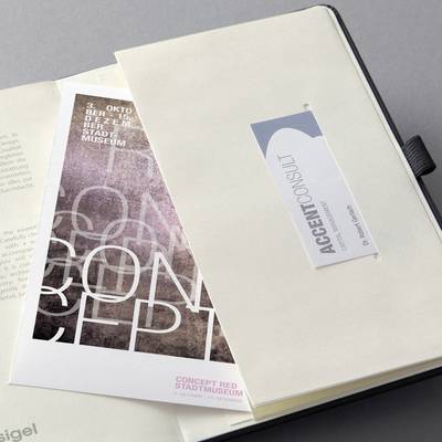 Ein Katalog 'CONCEPT RED' vom Stadtmuseum mit dekorativem Design und eine Visitenkarte von "ACCENT CONSULT" in einem Ordner.