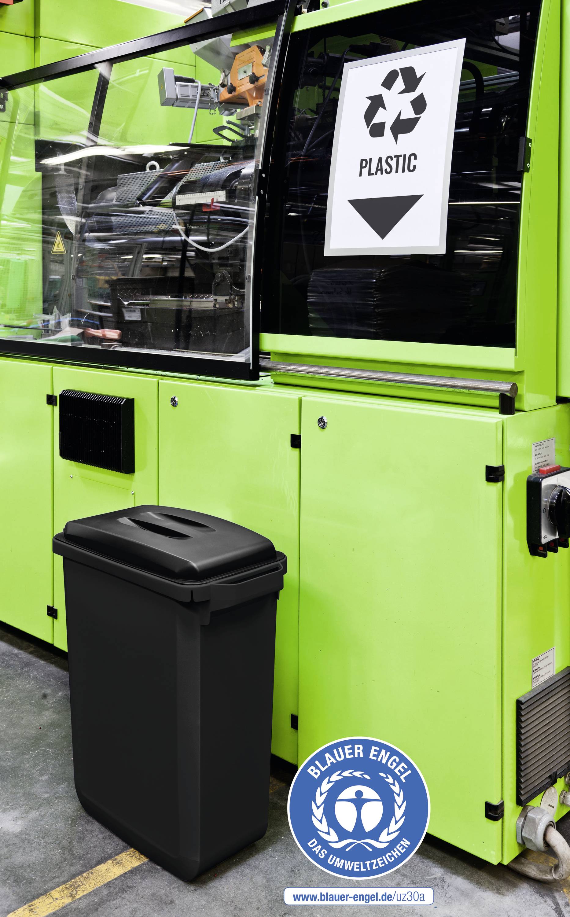 Eine grüne Maschine mit einem Schild 'Plastic Recycling'. Davor ein schwarzer Mülleimer. Unten rechts ist das 'Blauer Engel'-Logo.