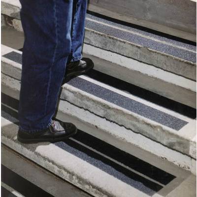 Person steigt eine Treppe hinauf, die mit rutschfesten Streifen auf den Stufen versehen ist, um die Sicherheit zu erhöhen.