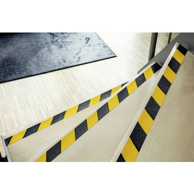 Treppe mit gelb-schwarzen Warnstreifen auf den Stufenkanten zur Erhöhung der Sichtbarkeit und Sicherheit in einem modernen Gebäude.