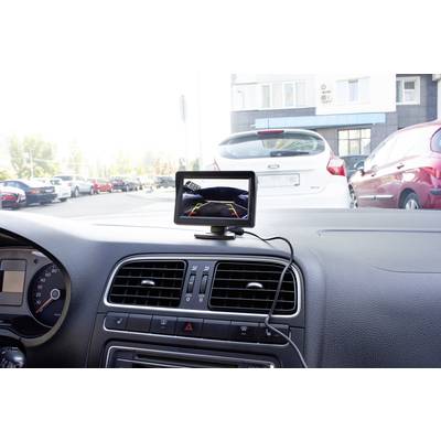 Ein Auto-Innenraum mit einem eingebauten Rückfahrkamera-Monitor, der die Umgebung hinter dem Auto auf einem Bildschirm zeigt.
