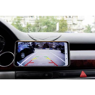 Ein Smartphone zeigt auf einem Armaturenbrett den Rückfahrkamera-Bildschirm mit farbigen Linien zur Einparkhilfe in einem Parkplatz.