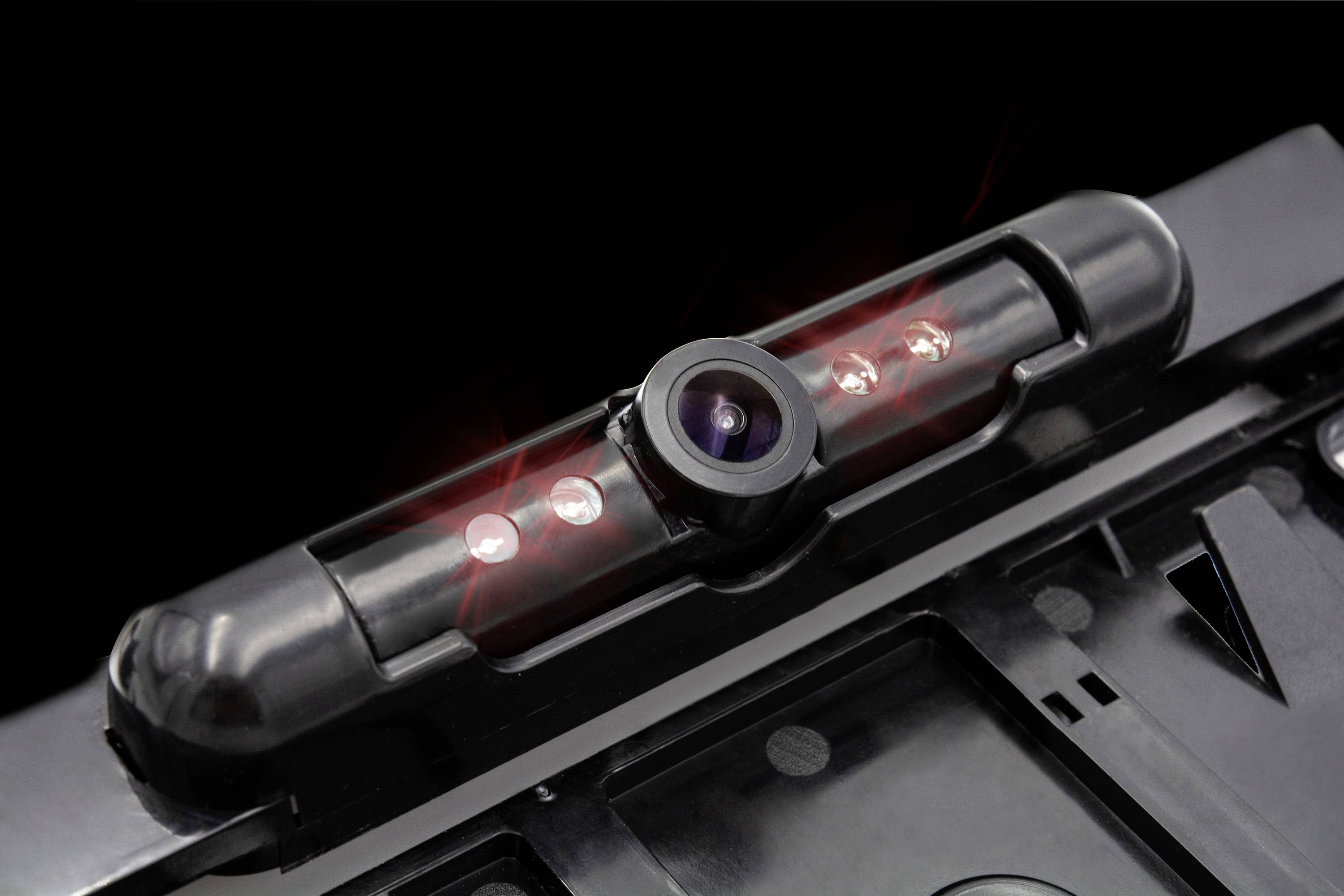 Nahaufnahme einer Rückfahrkamera mit leuchtenden LEDs an einem Auto, die bei Dunkelheit klare Sicht unterstützt.