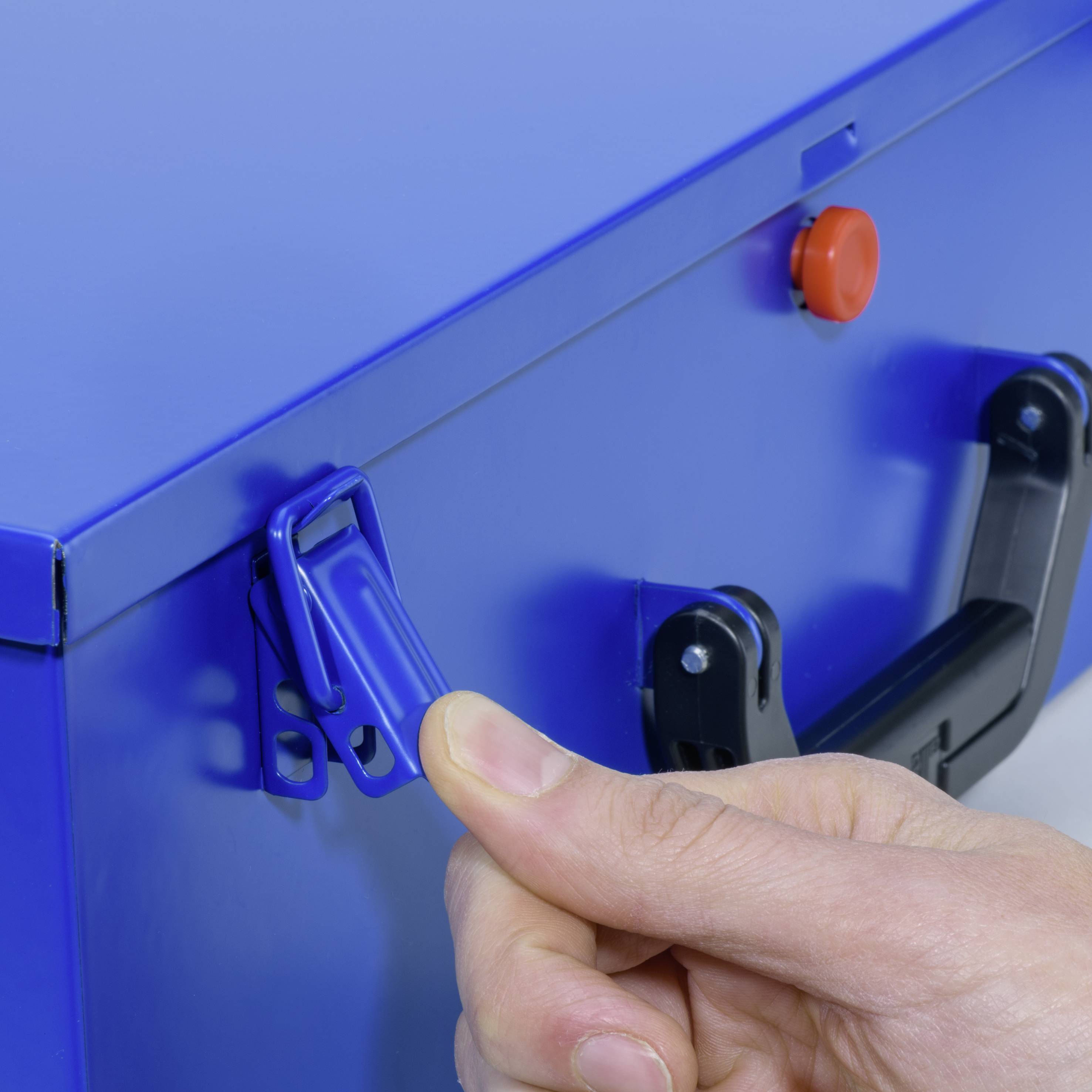 Ein Finger betätigt den Verschluss einer blauen Box mit einem Hebelgriff.