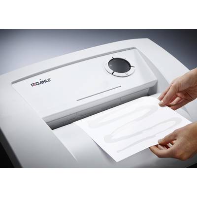 Person schiebt ein Blatt Papier in einen Aktenvernichter. Das Gerät hat eine weiße Oberfläche und eine Bedienungsanzeige mit Drehknopf.