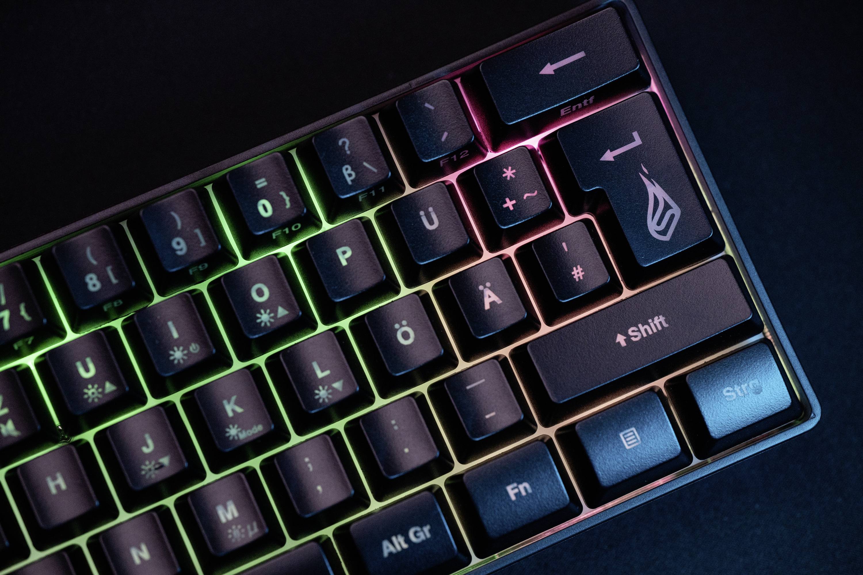 Eine mechanische Tastatur mit regenbogenfarbiger Hintergrundbeleuchtung; einige Tasten sind angepasst oder markiert, einschließlich eines Logos.