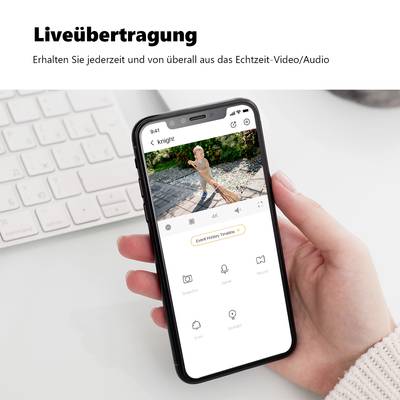 Eine Person hält ein Smartphone mit einer Überwachungs-App geöffnet, darunter der Text: 'Liveübertragung'.