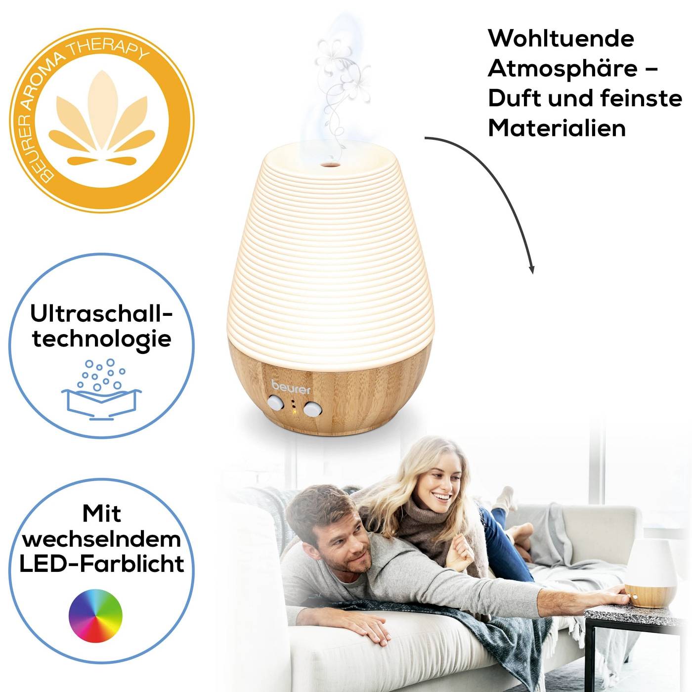 Ein Aroma-Diffuser mit Holzdesign, der mithilfe von Ultraschalltechnologie Duft verströmt. Ein Paar entspannt daneben auf der Couch.