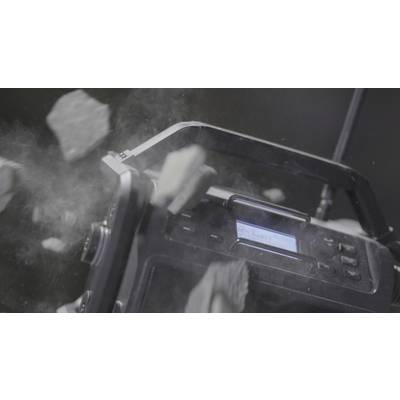 Ein robustes Radio wird von herabfallenden Trümmern getroffen, illustriert die Strapazierfähigkeit des Geräts unter extremen Bedingungen.