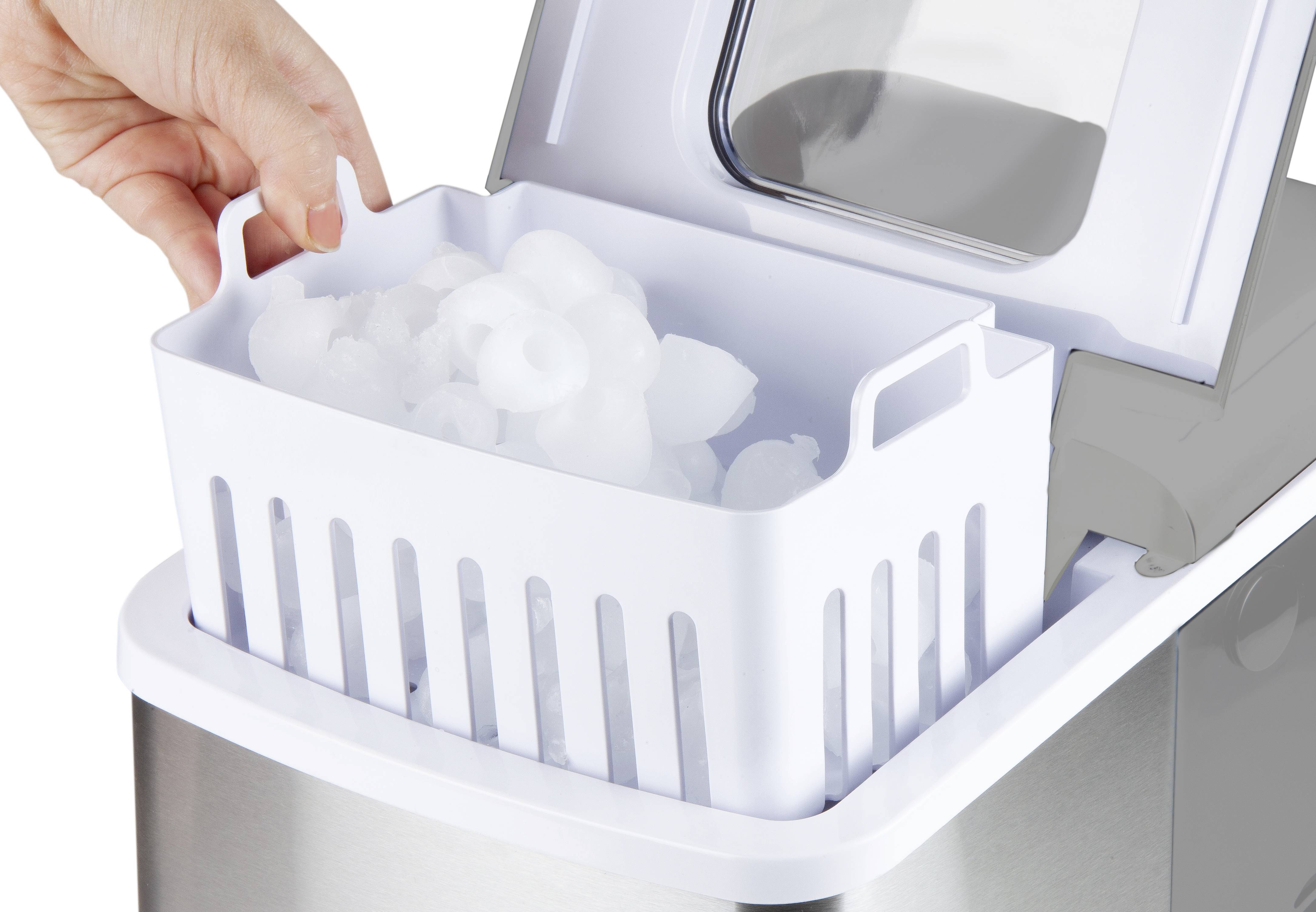 Eine Hand hebt einen Korb mit frischen Eiswürfeln aus einer geöffneten Eismaschine.