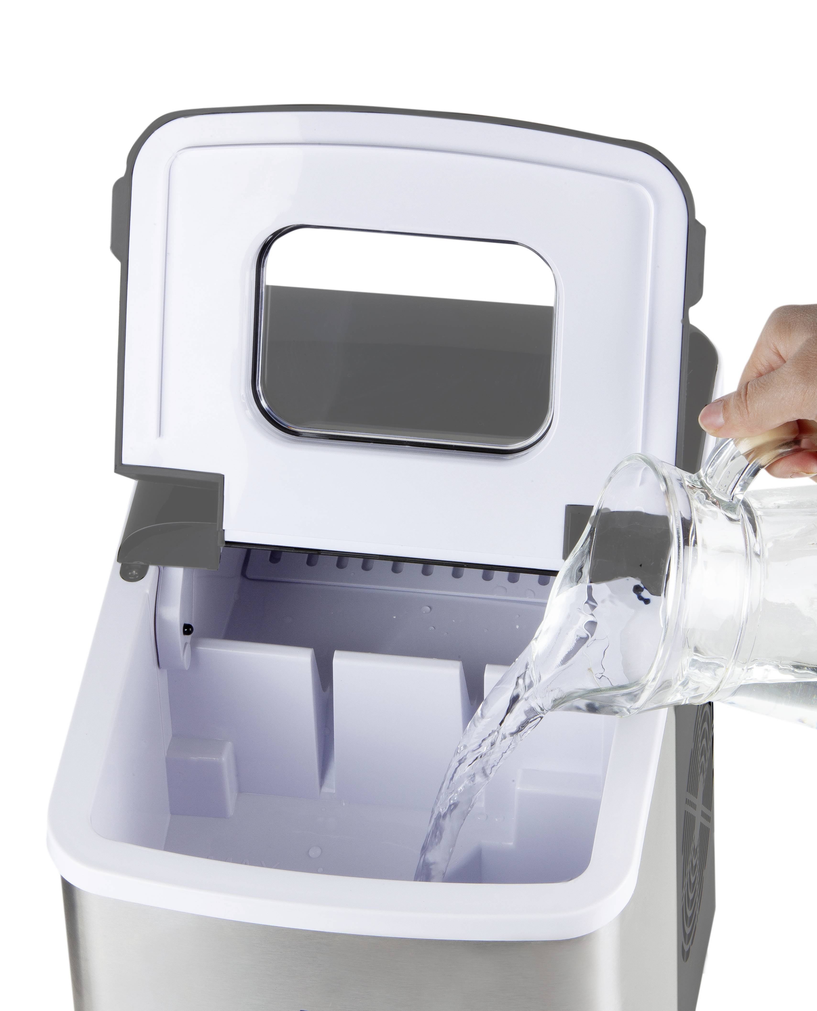 Eine Person gießt Wasser aus einem Krug in eine geöffnete tragbare Eismaschine.