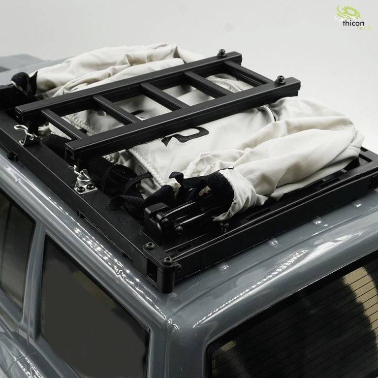 Dachträger eines grauen Modells mit Leiter und eingepacktem Zubehör, geeignet für Abenteuerreisen oder Transportzwecke.