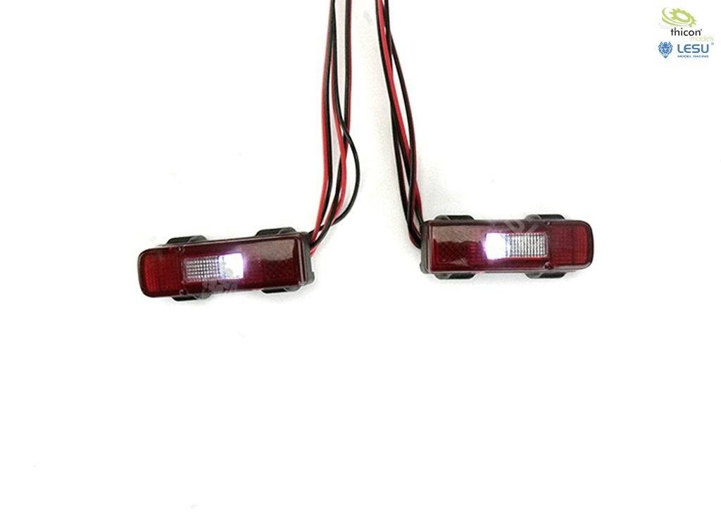 Zwei rote LED-Leuchten mit schwarzen Rahmen und Kabeln auf weißem Hintergrund, bereit zur Installation oder zum Anschluss.