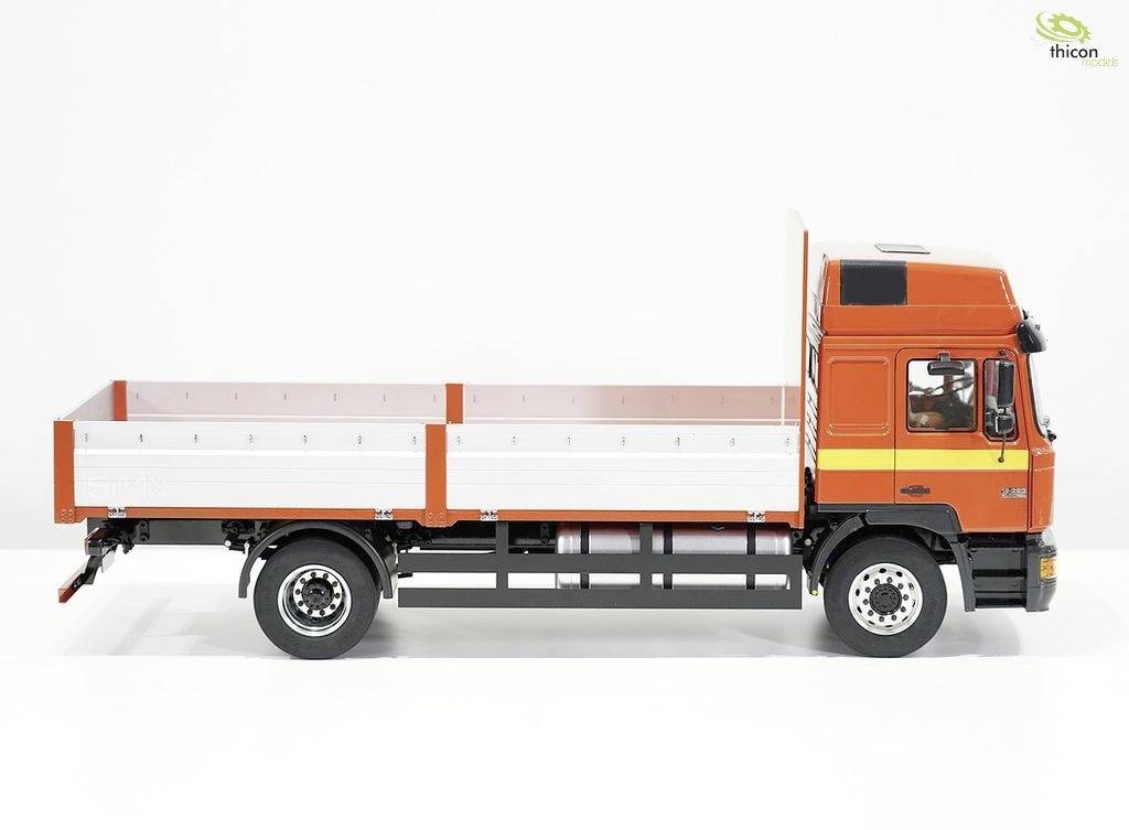 Ein orangener Lastwagen mit flacher Ladefläche, seitlich fotografiert, vor weißem Hintergrund.