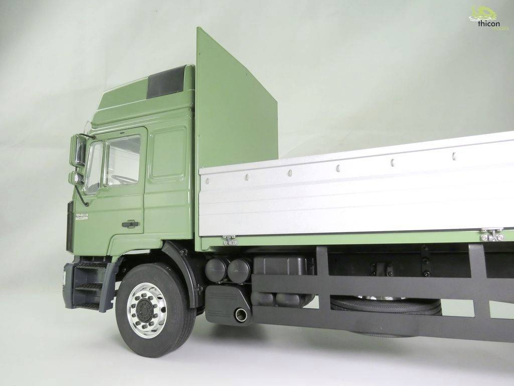 Grüner Lastwagen im Profilansicht, mit weißer Ladefläche auf grauem Hintergrund. Kein zusätzlicher Kontext angegeben.