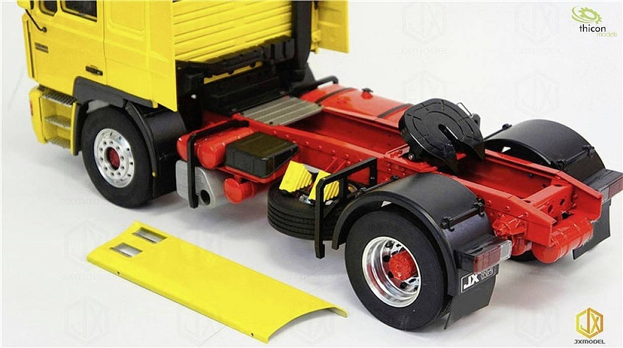 Gelbes und rotes Modell eines Lkw-Chassis ohne Aufbau oder Anhänger auf weißem Hintergrund.
