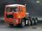 Ein rotes Modell-LKW mit vier Achsen, beschriftet mit 'SCALECLUB'. Im Hintergrund ist ein Logo mit 'flicon models' sichtbar.