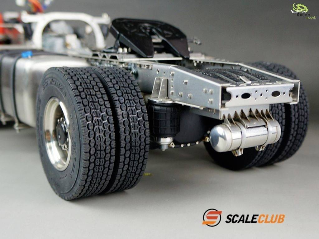 Ein Modell-LKW-Chassis mit sichtbarem Rahmen, Reifen und einigen mechanischen Komponenten. Markenlogo 'SCALECLUB' unten rechts im Bild.