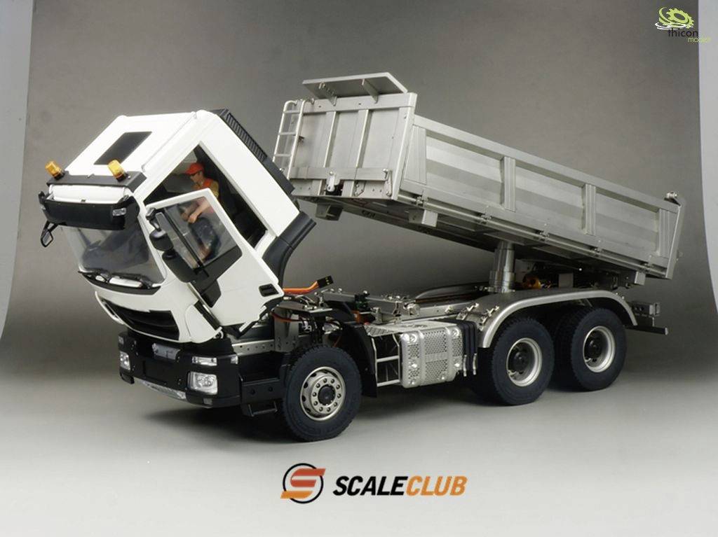 LKW-Modell mit kippbarer Ladefläche, Kabine nach vorne geneigt, auf grauem Hintergrund. Beschriftet mit 'ScaleClub' unten.