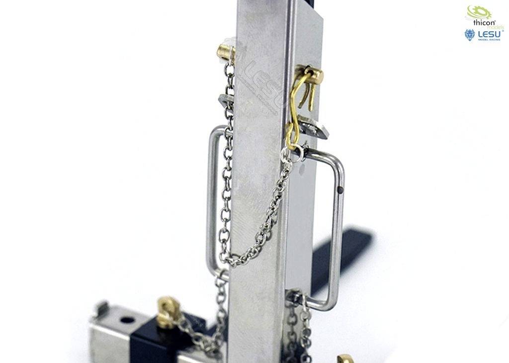 Metallisches Modellbauteil mit Gliederkette und Haken. Funktionelle Teile sichtbar. Firmenlogos oben rechts im Bild.