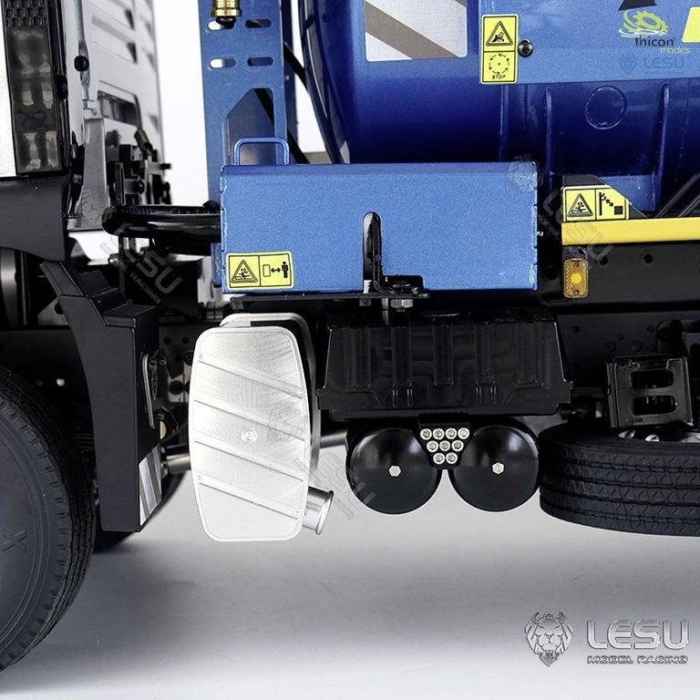 Blauer Tank mit gelben Warnsymbolen und silbernem Zylinder an der Seite eines Fahrzeugrahmens. Offensichtlich technische Fahrzeugkomponente.