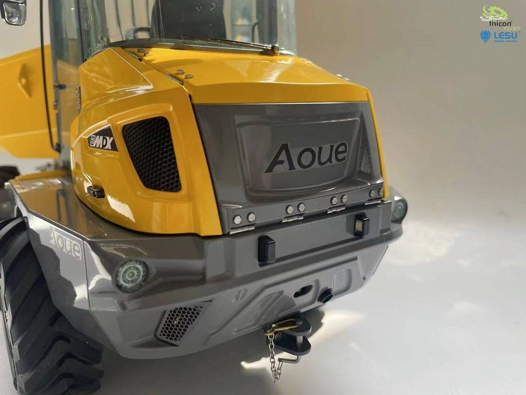 Gelber und grauer Modellbau-Bagger von vorne, mit Aufschrift 'Aoue' auf der Motorhaube, auf weißem Hintergrund.