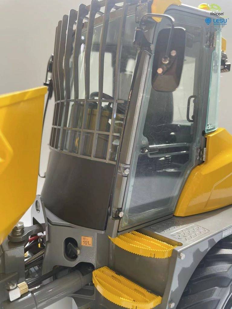 Ein detailliertes Modell eines gelben Baufahrzeugs mit angebrachter Sicherheitsgitterkabine und gelben Trittstufen.