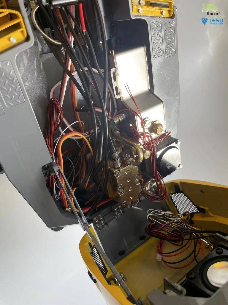 'Nahaufnahme eines komplexen Maschineninneren mit zahlreichen farbigen Kabeln und metallischen Komponenten, Teil eines technischen Geräts.'