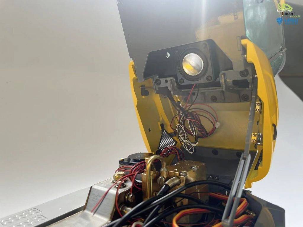 Ein geöffneter elektronischer Apparat mit sichtbaren Drähten und Komponenten im Inneren. Links ein flacher, heller Bereich.