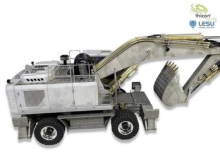 Ein hochdetailliertes Modell eines Baggers in silberner Farbe mit schwarzem Arm und goldfarbenen Hydraulikzylindern auf weißem Hintergrund.