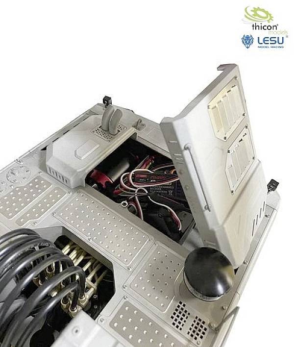 Ein offenes Gehäuse eines Fahrzeugs oder Roboters, das elektronische Komponenten, Kabel und mechanische Teile zeigt.