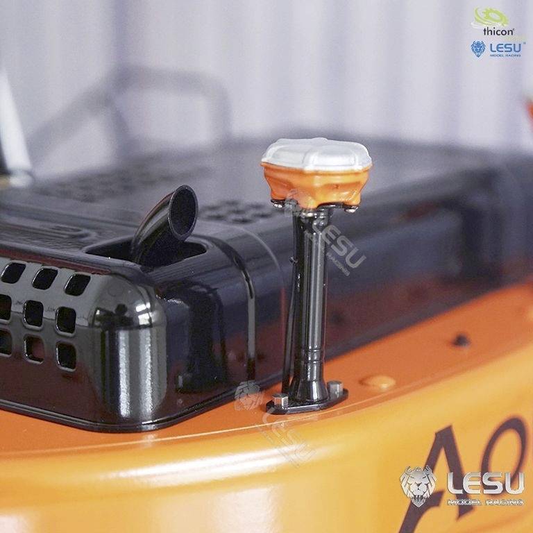 Nahaufnahme eines technischen Modells mit orange-schwarzer Oberfläche und einem kleinen weißen runden Aufsatz. Logos im Hintergrund oben rechts.